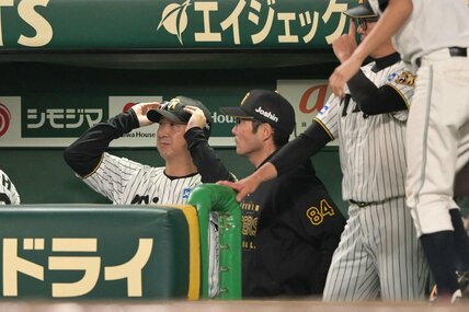９回、ベンチで渋い表情の阪神・藤川監督(左)