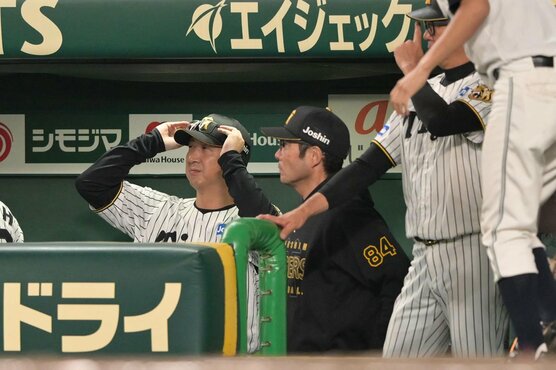 ９回、ベンチで渋い表情の阪神・藤川監督(左)