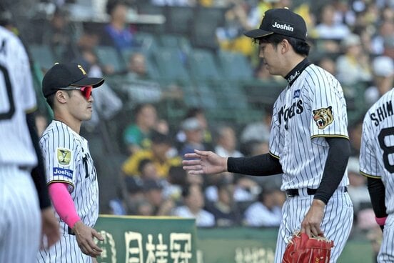 ベンチに戻る才木（右）を迎える阪神・坂本