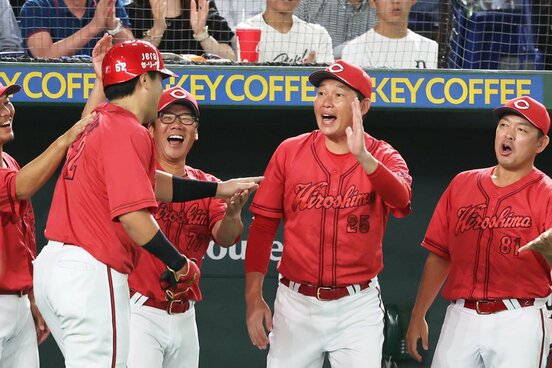 ４回、満塁一掃打を放った末包(手前左)を笑顔で迎える広島・新井監督