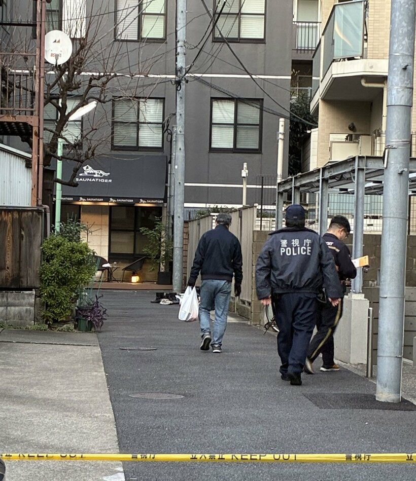 火災のあったサウナ店に入る警視庁署員